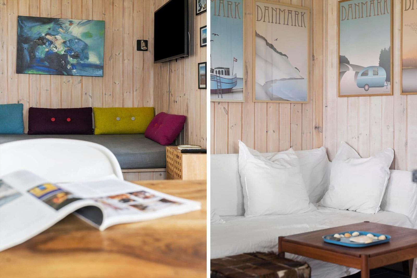 Wohnzimmer mit Holzwand, Sofa, Kissen und Fernseher. Wandbilder zeigen Dänemark.