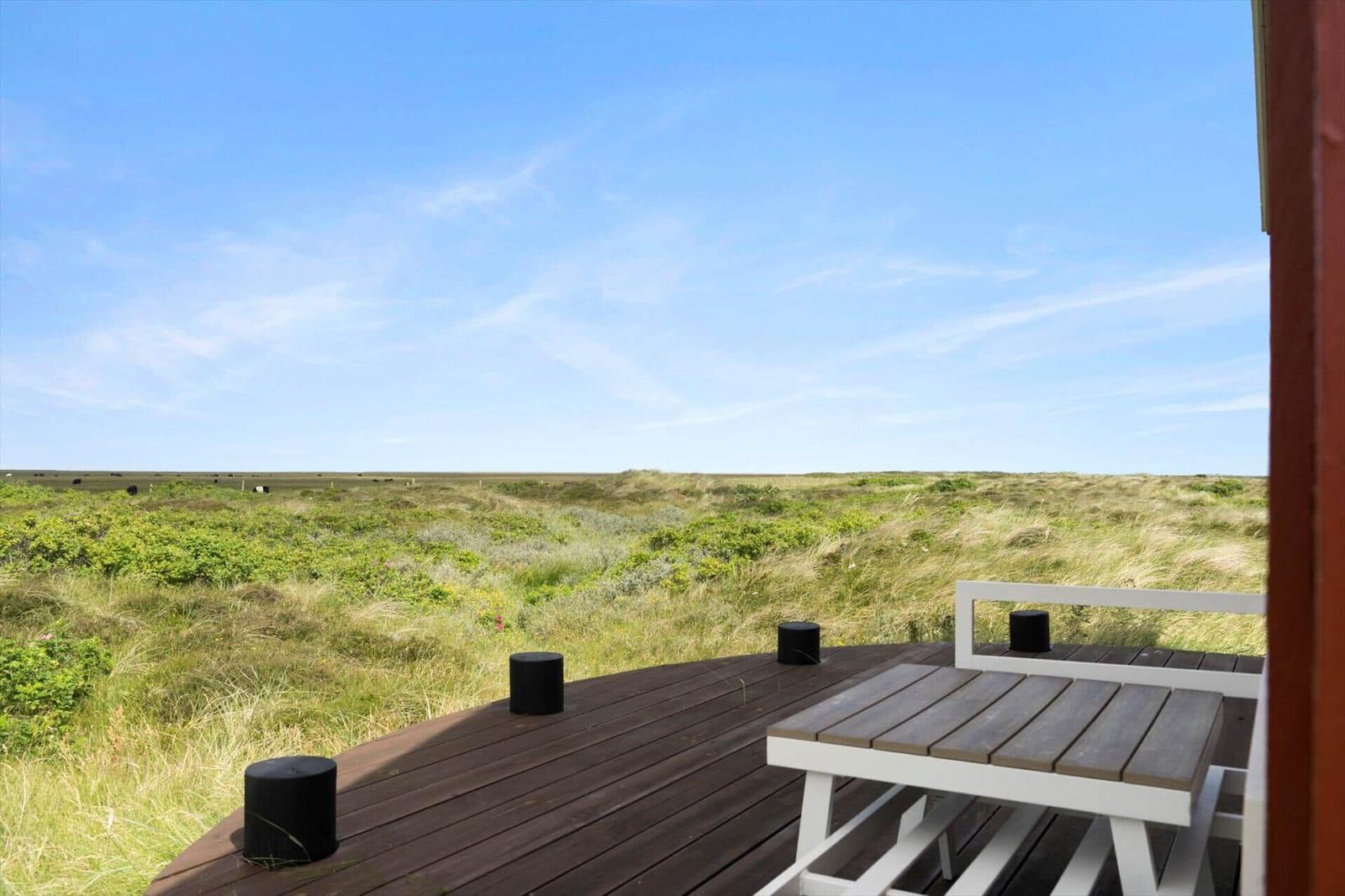 Terrasse mit Sitzgelegenheit und Blick auf die grüne Landschaft.
