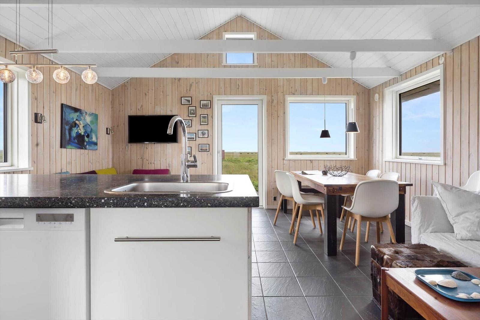 Küche mit Essbereich, Holzwände und Fenster zum Ausblick.