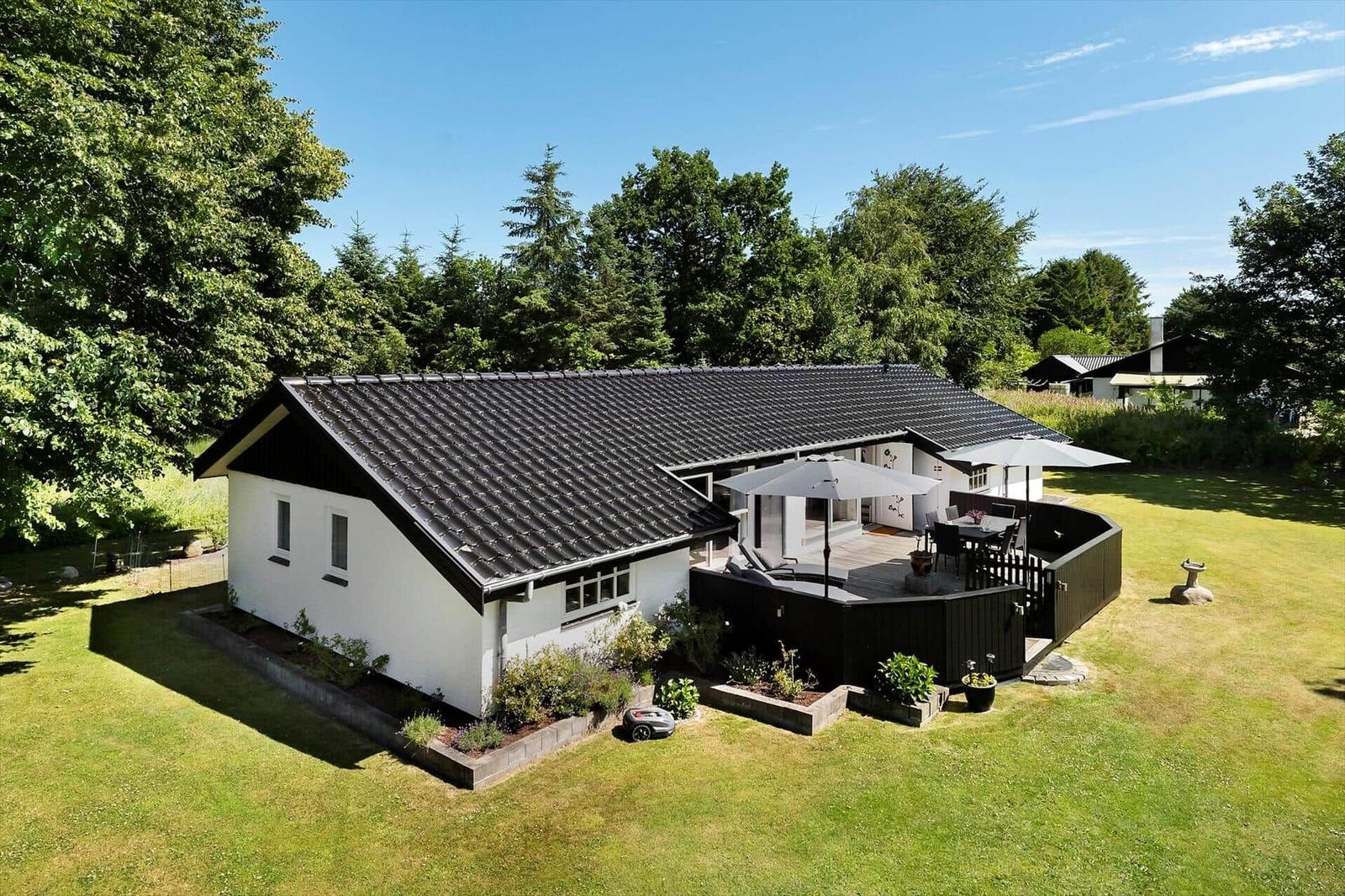 Wohnhaus mit Terrasse, Garten und Umgebung mit Bäumen.