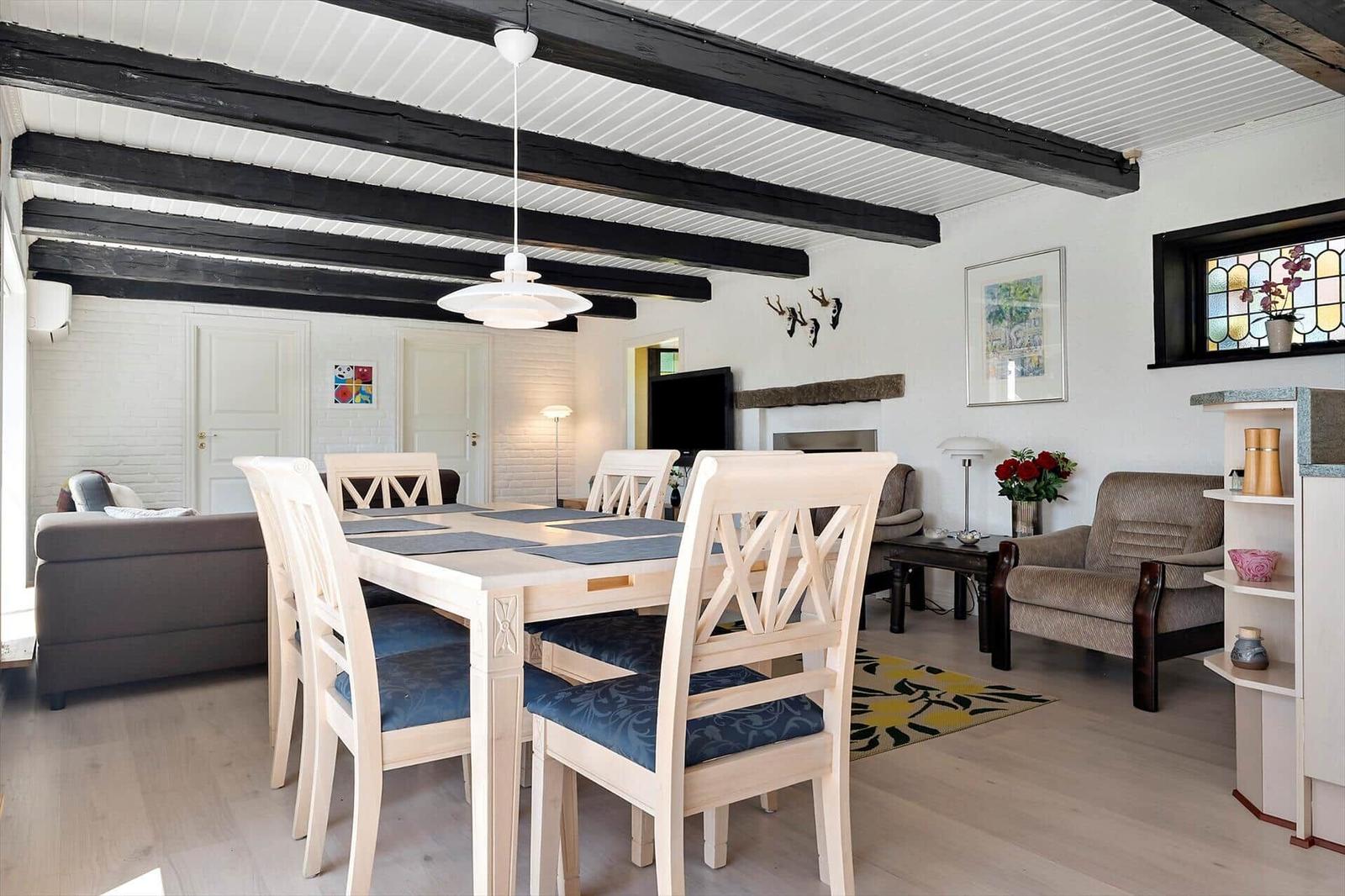 Essbereich mit Tisch und Stühlen, Wohnbereich mit Sofa und Kamin