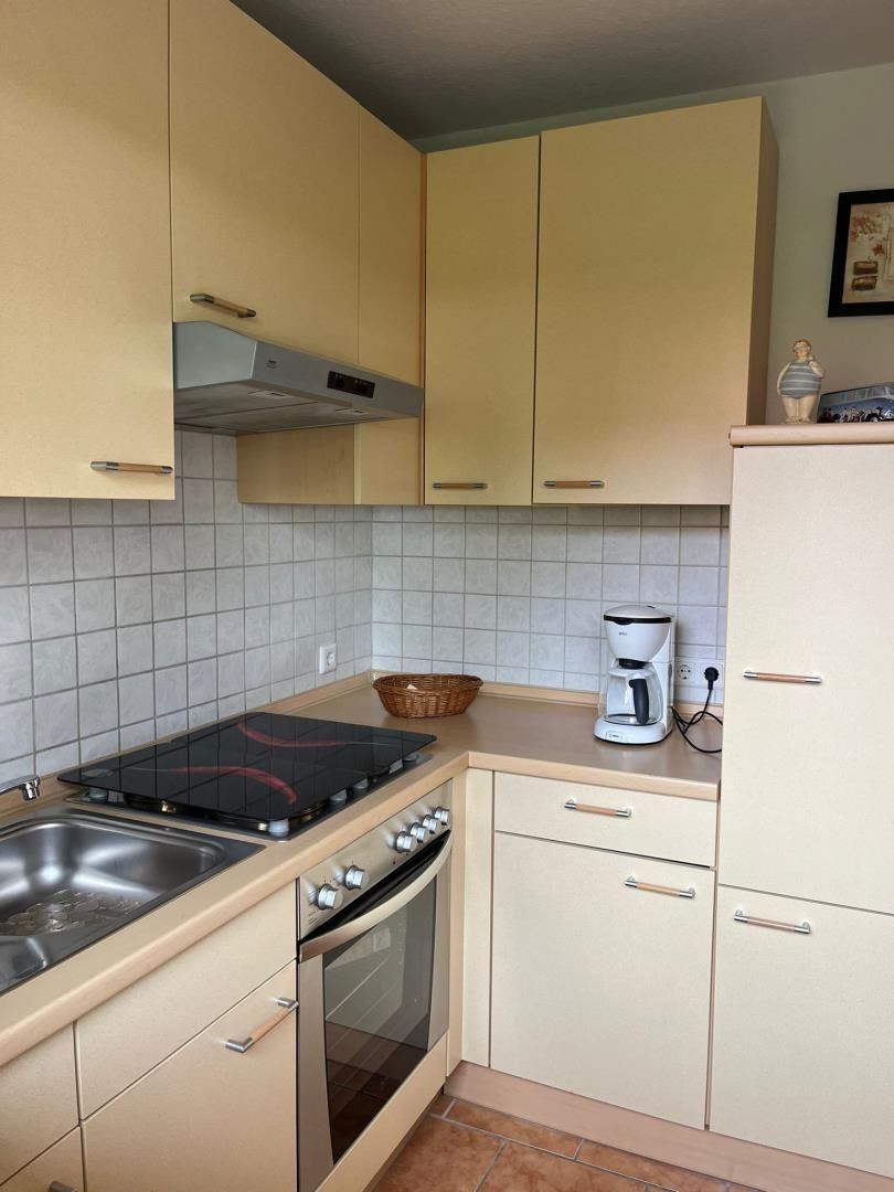 Küche mit Herd, Spüle und Kaffeemaschine