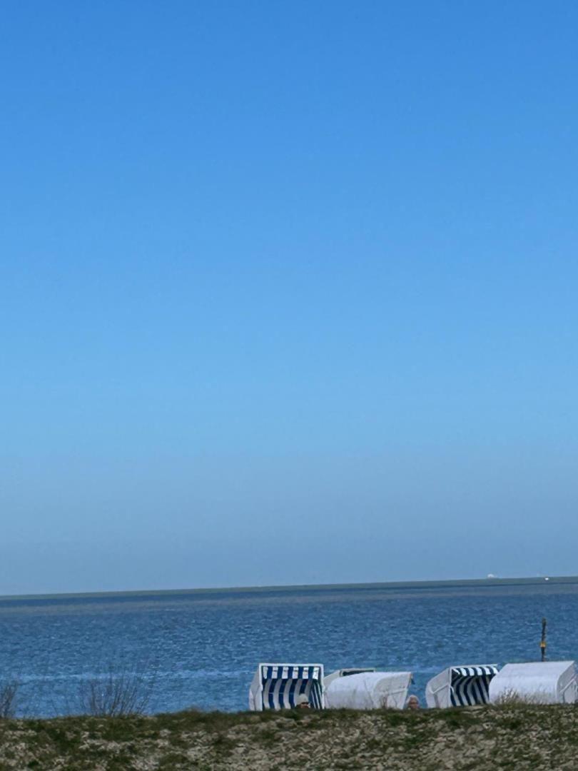 Strand mit Strandkörben und blauem Himmel. Blick auf das Meer.