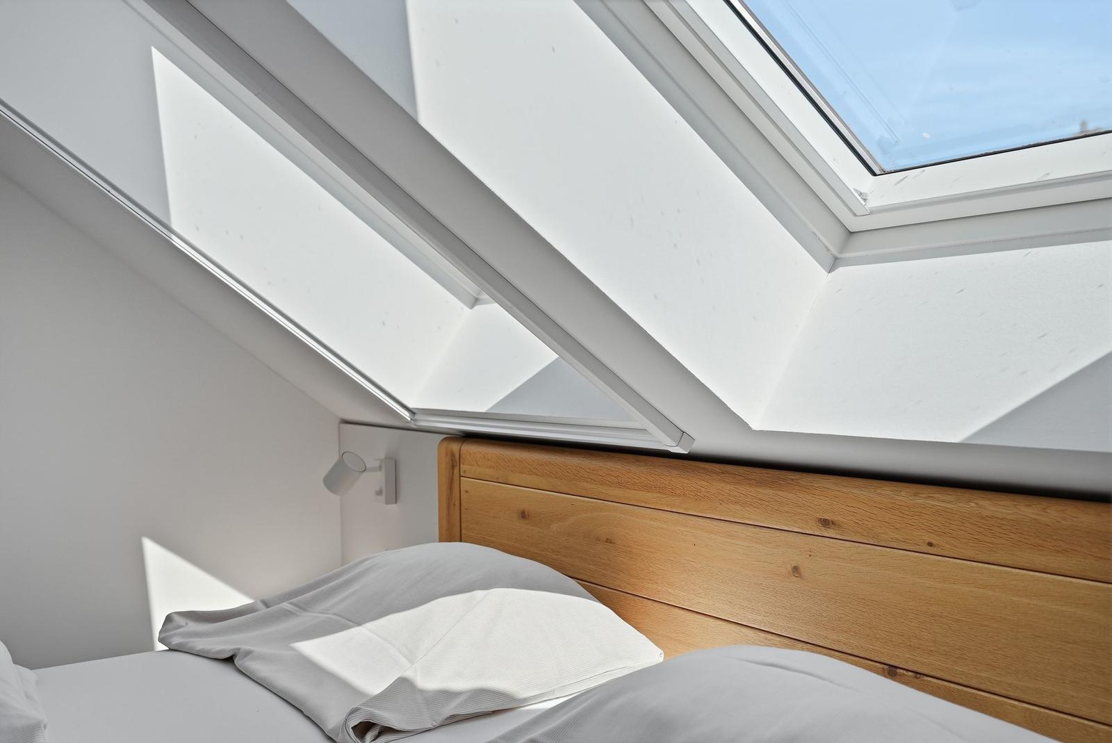 Dachgeschosszimmer mit Dachfenster und Holzkopfteil