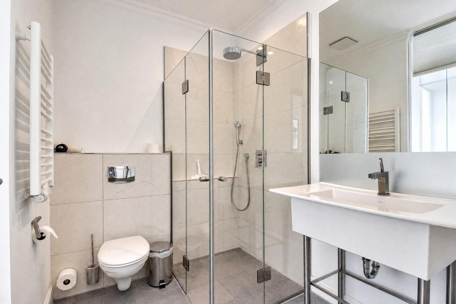 Badezimmer mit Dusche, Waschbecken und Toilette.