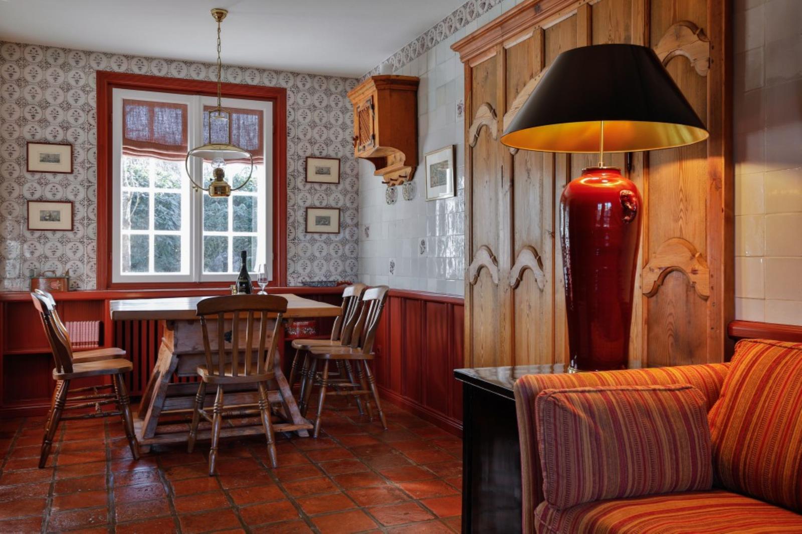 Esszimmer mit Holztisch, Stühlen und Fenster. Wohnbereich mit Sofa und Stehlampe.