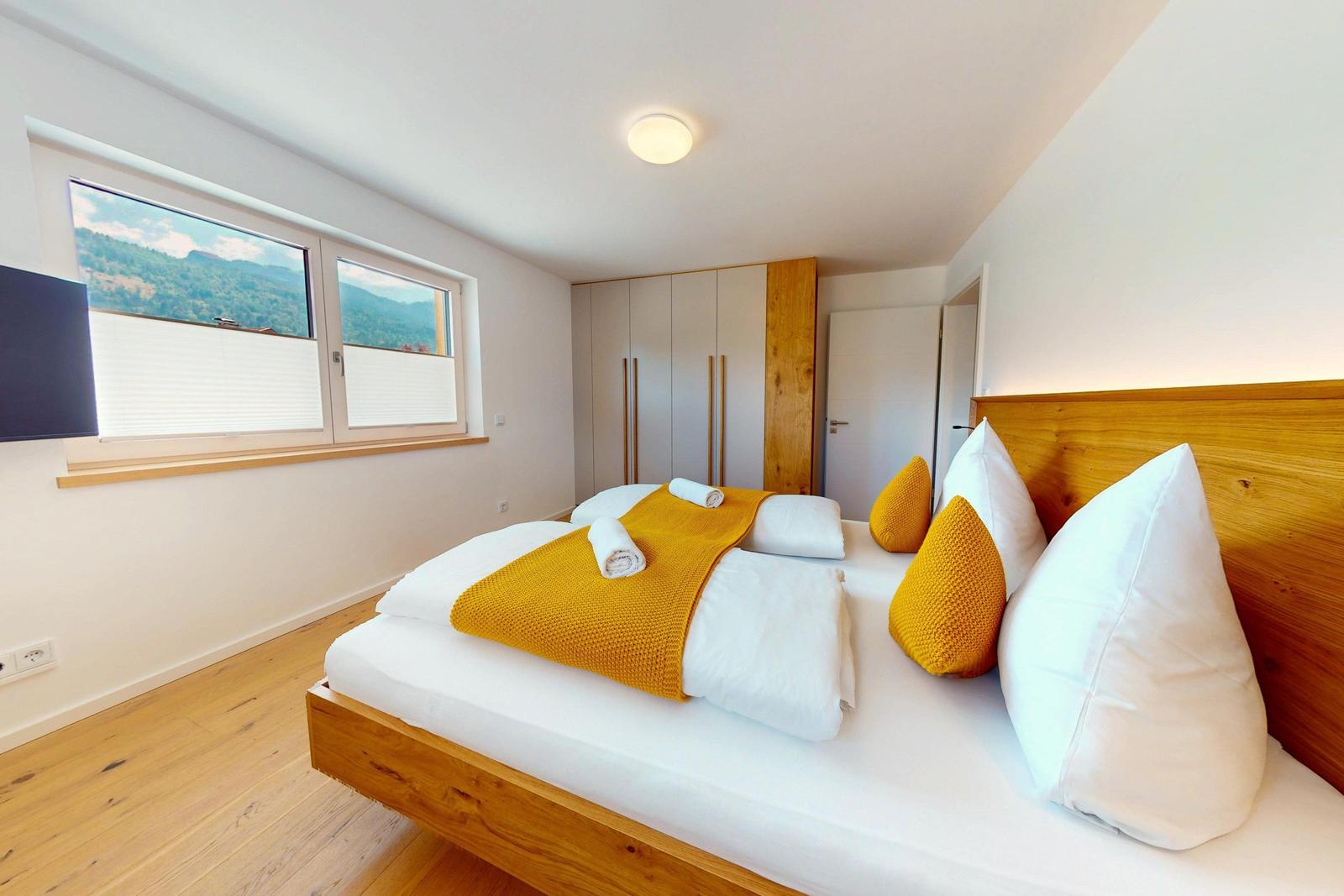 Schlafzimmer mit Bett, Fenster und Kleiderschrank