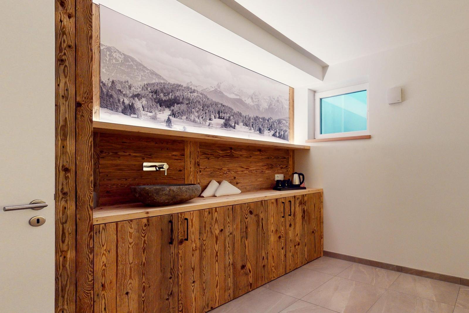 Holzpaneel-Wand mit Waschbecken, Kaffeemaschine und Wandbild