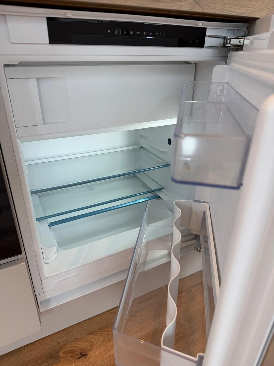Der Kühlschrank ist leer und hat mehrere Glasböden sowie einen Gefrierfachbereich.