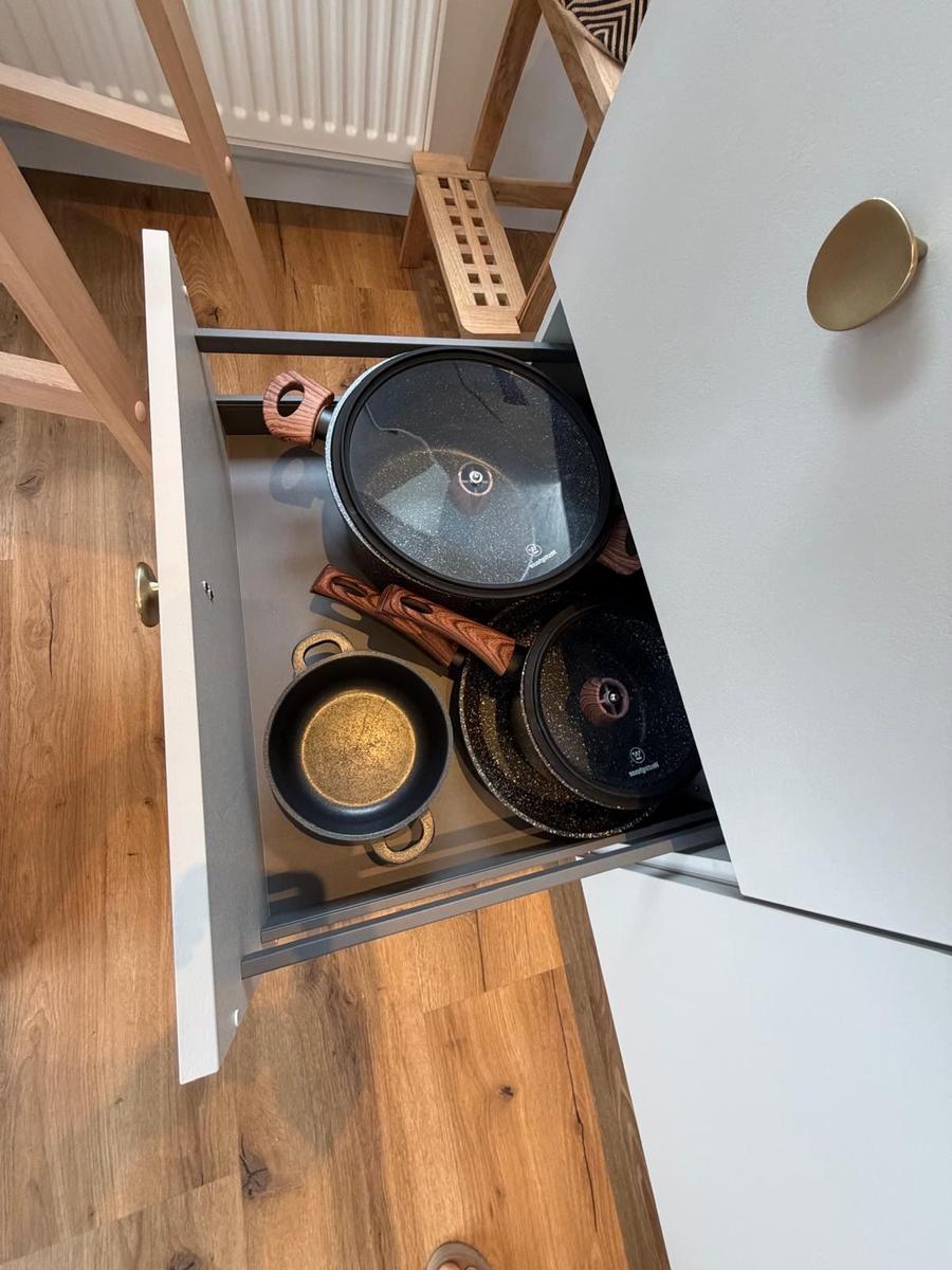 Küchenschrank mit Pfannen und Deckeln