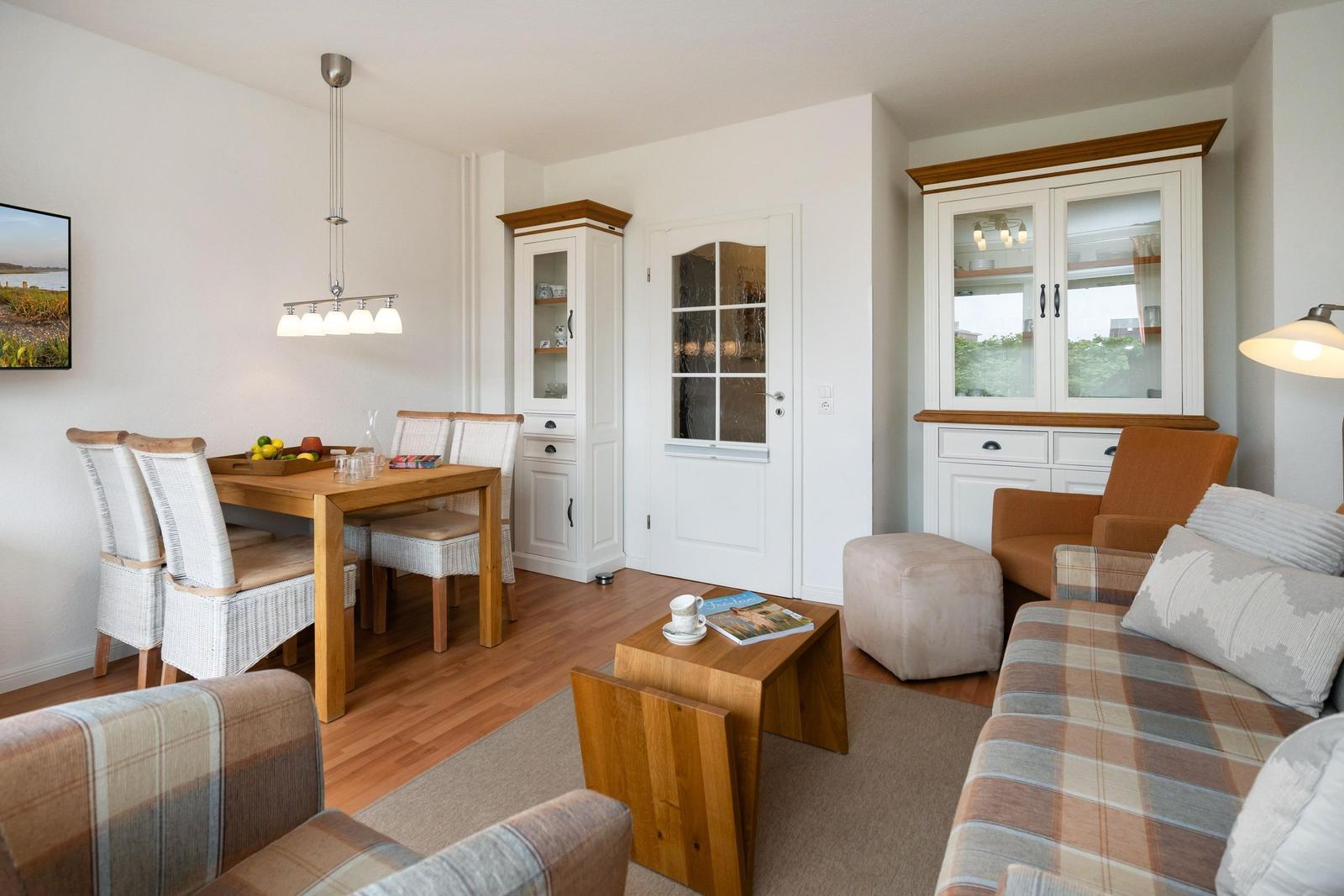 Wohn- und Essbereich mit Holzmöbeln, Sofa und Küchenschränken.
