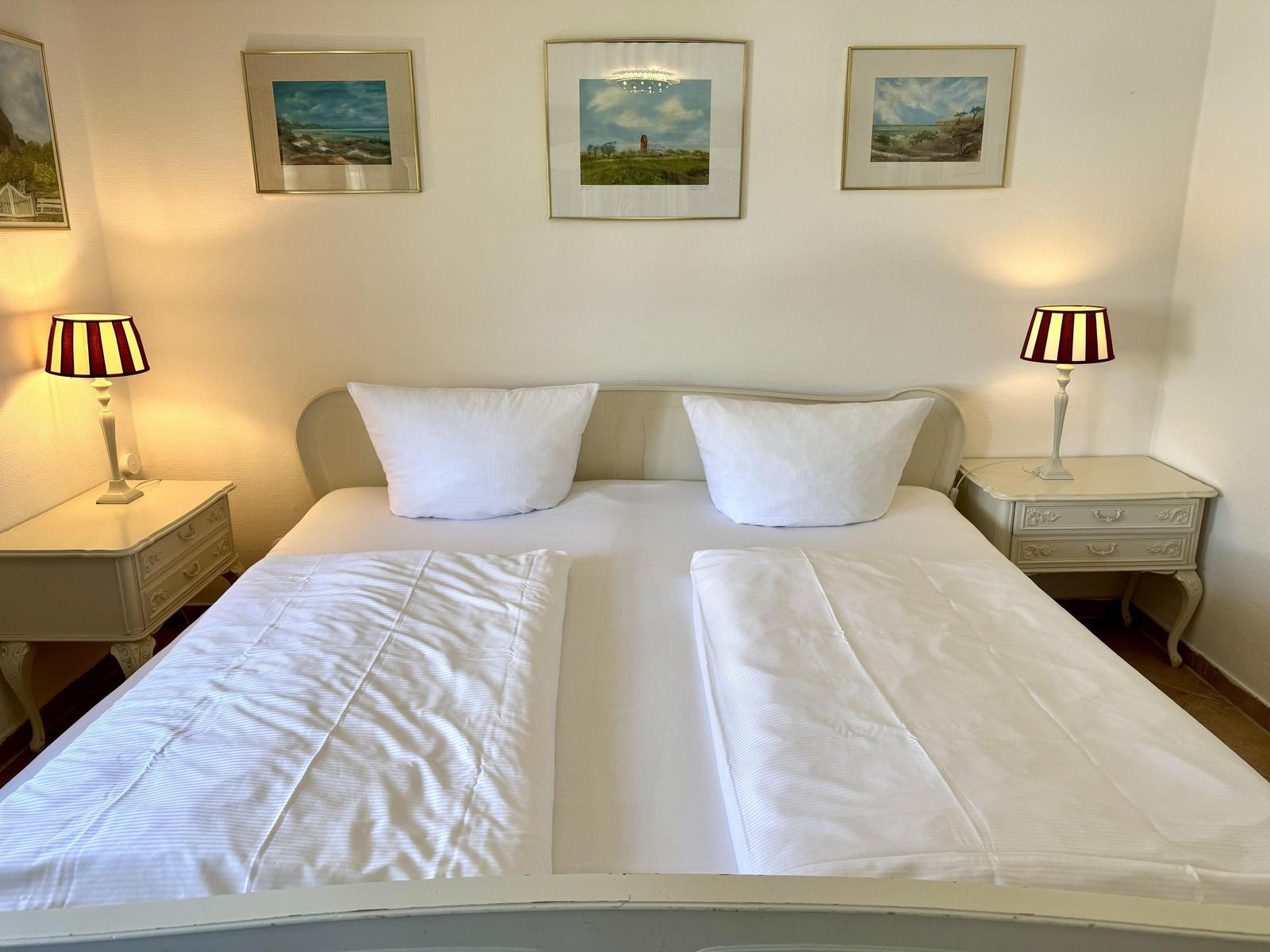 Bedroom with double bed, two nightstands, and lamps beside the bed.