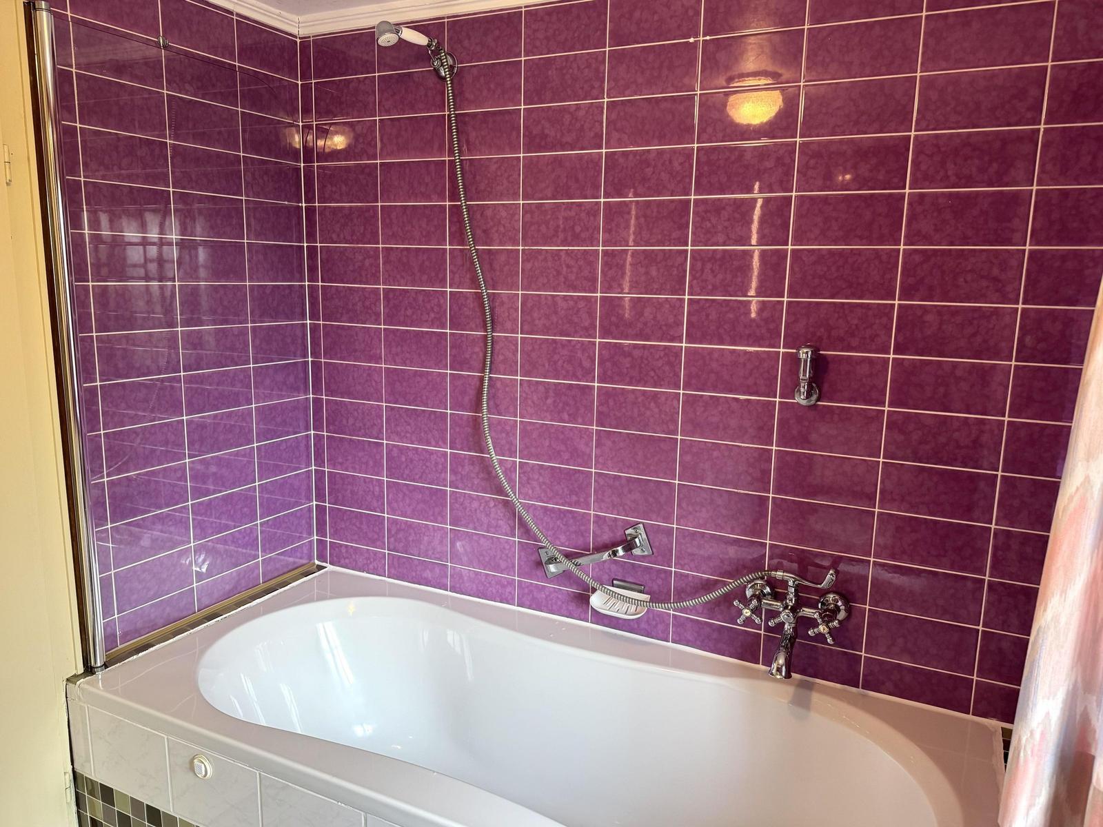 Bath with shower and bathtub, purple wall tiles