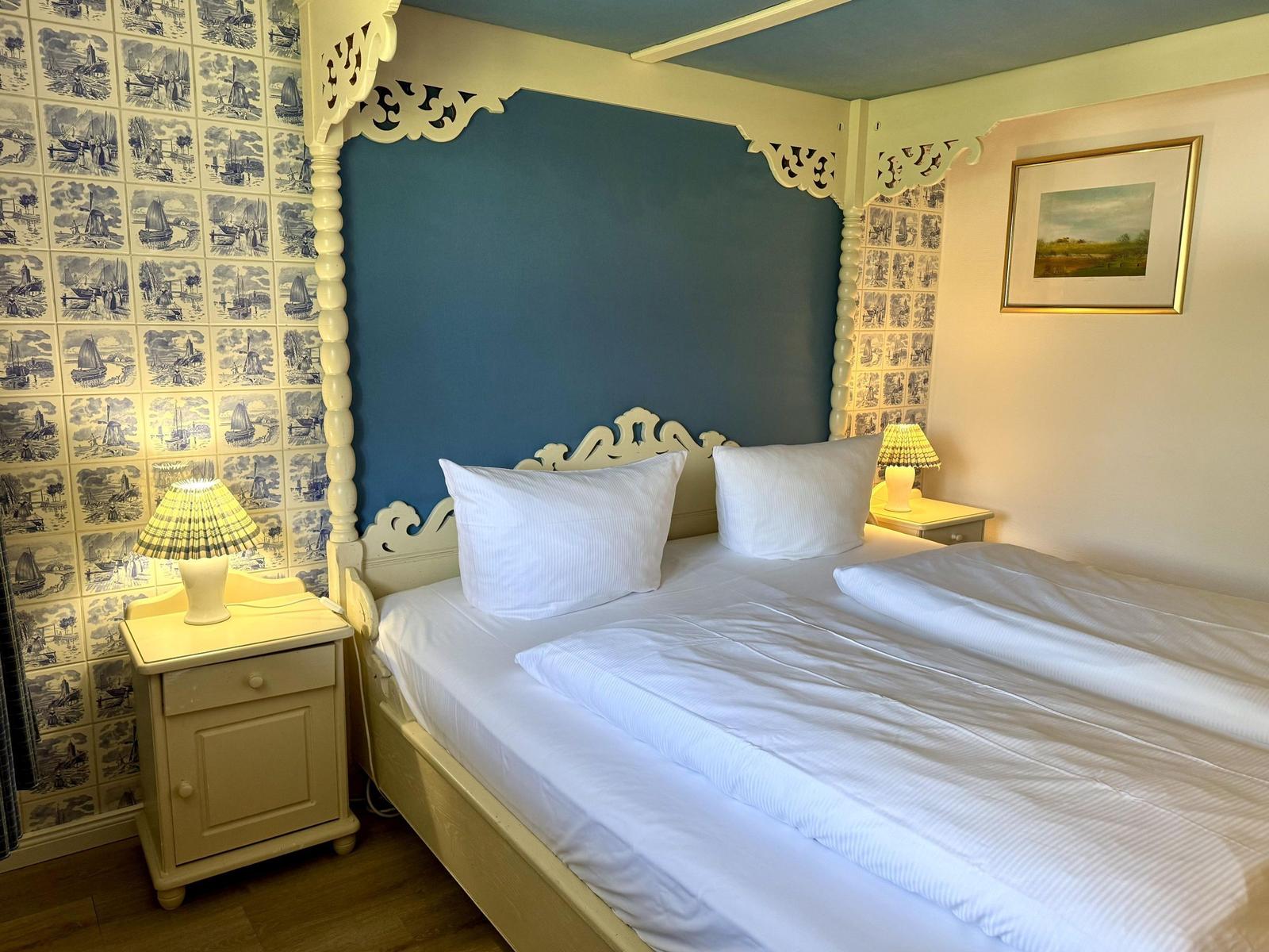Bedroom with bed, nightstands, and wall covering with motifs.