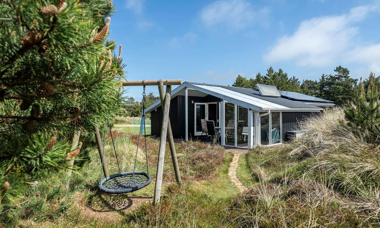 Haus mit Terrasse und Schaukel im Grasland