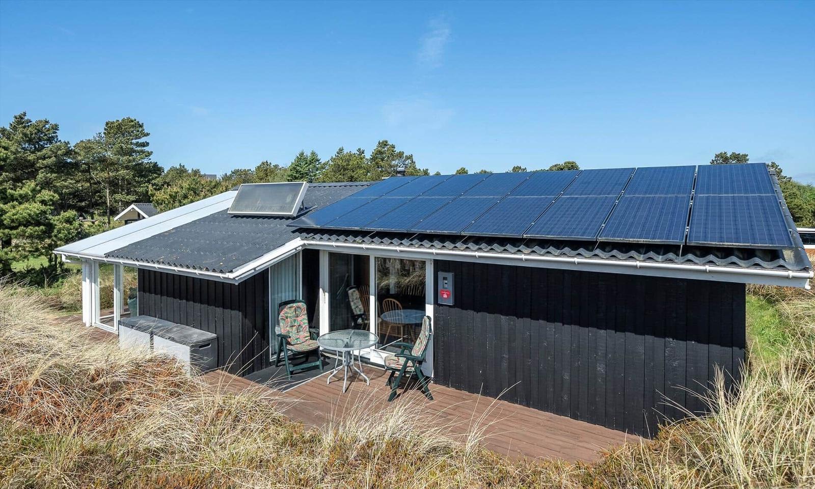 Ein Haus mit Solaranlage und Terrasse im Freien.