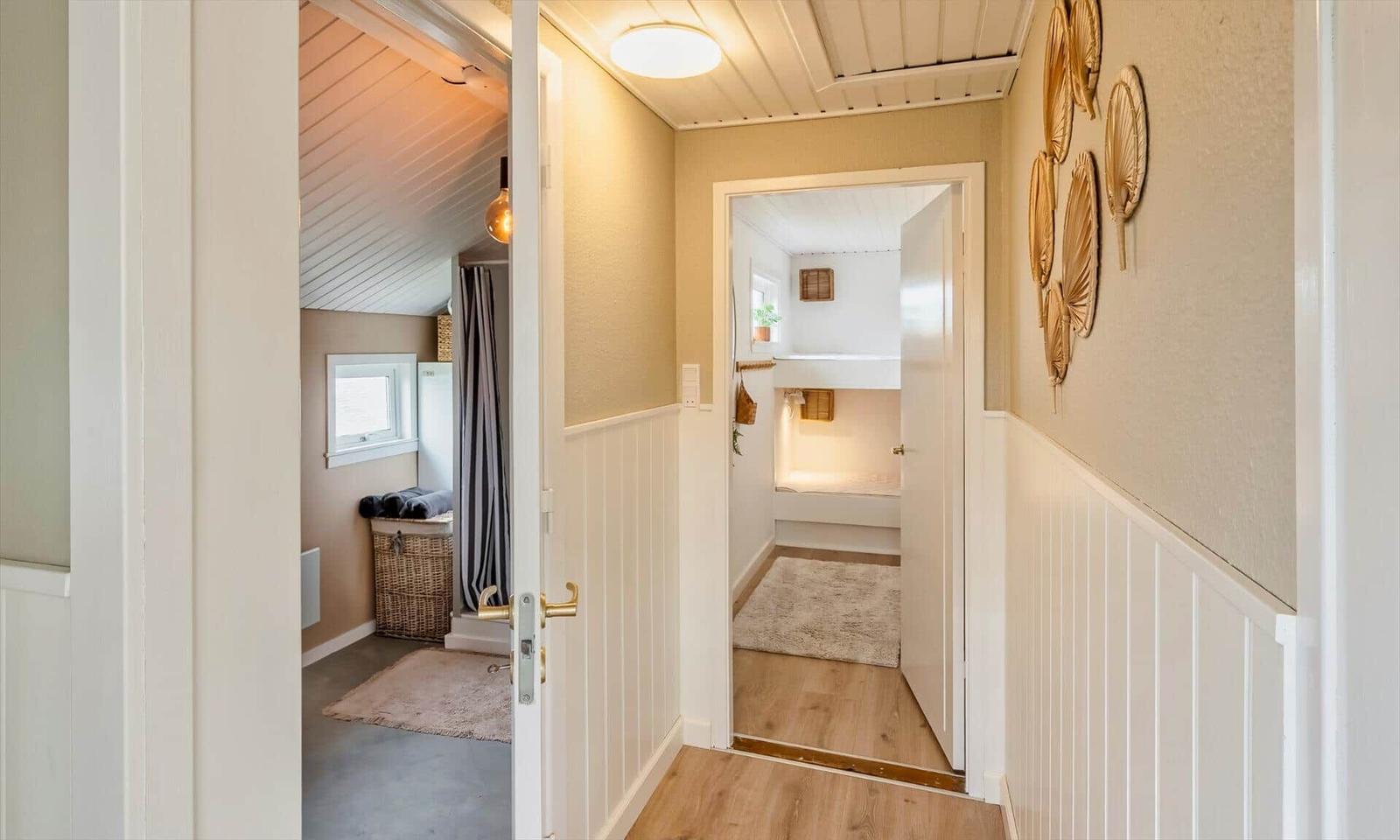 Hallway with two doors, one leads to a bathroom, the other to a bedroom.
