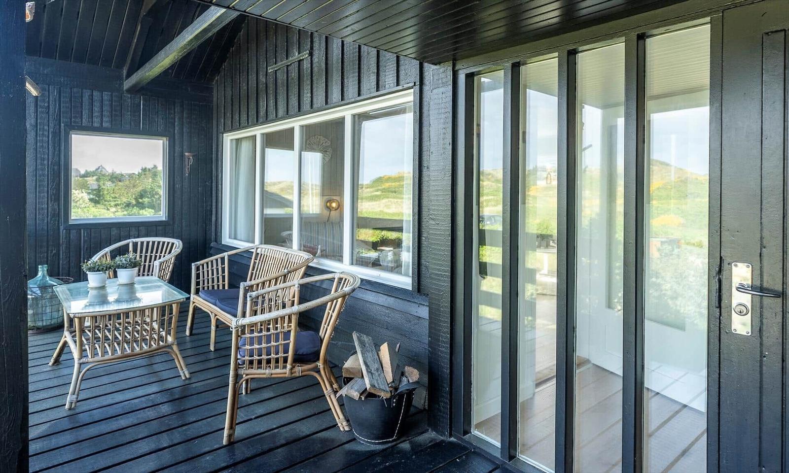 Patio with rattan furniture and view of green landscape.