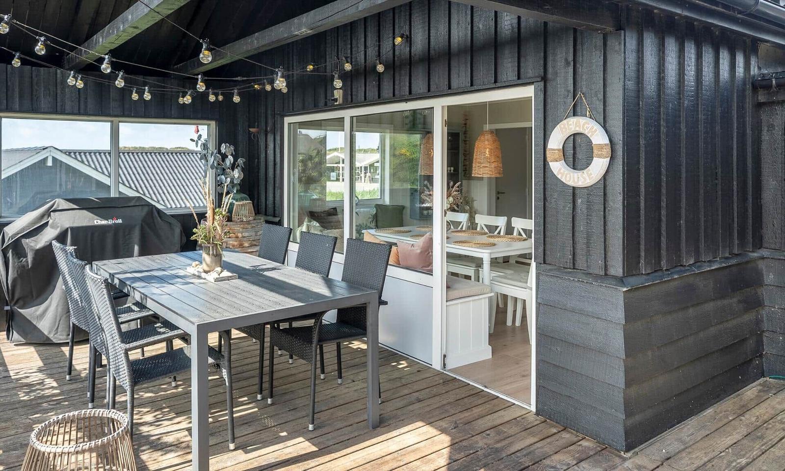Terrace with table, chairs, and grill. Entrance into house with dining area.