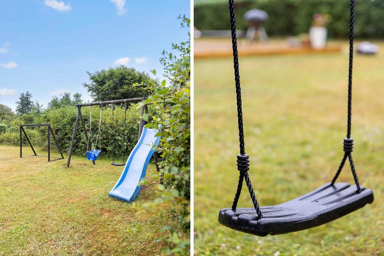 Hinterhof mit Schaukel, Rutsche und Fußballtor. Grasfläche und Bäume im Hintergrund.