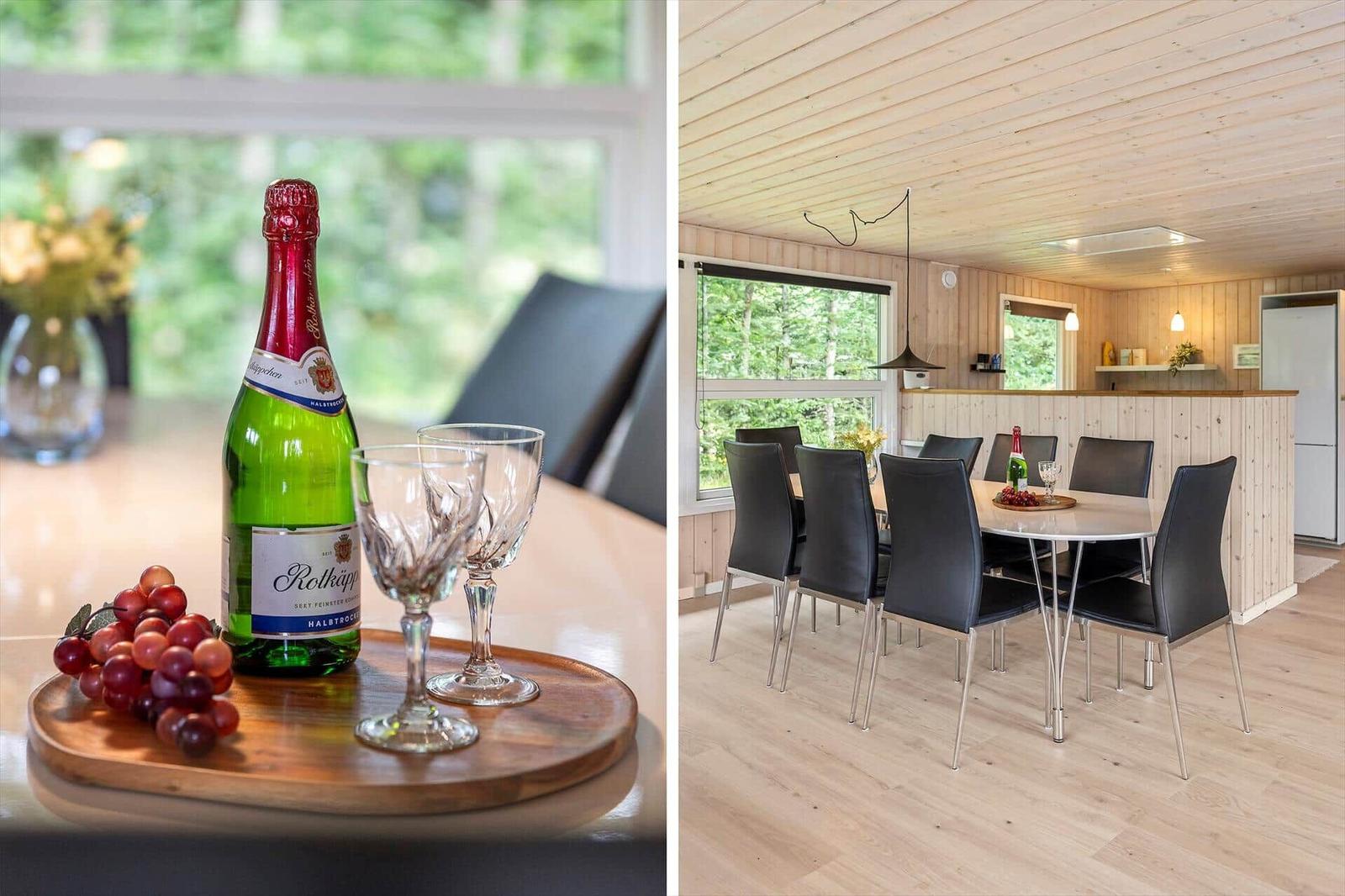 Esszimmer mit Holzdecke und -wänden. Tisch mit Gläsern und Trauben.