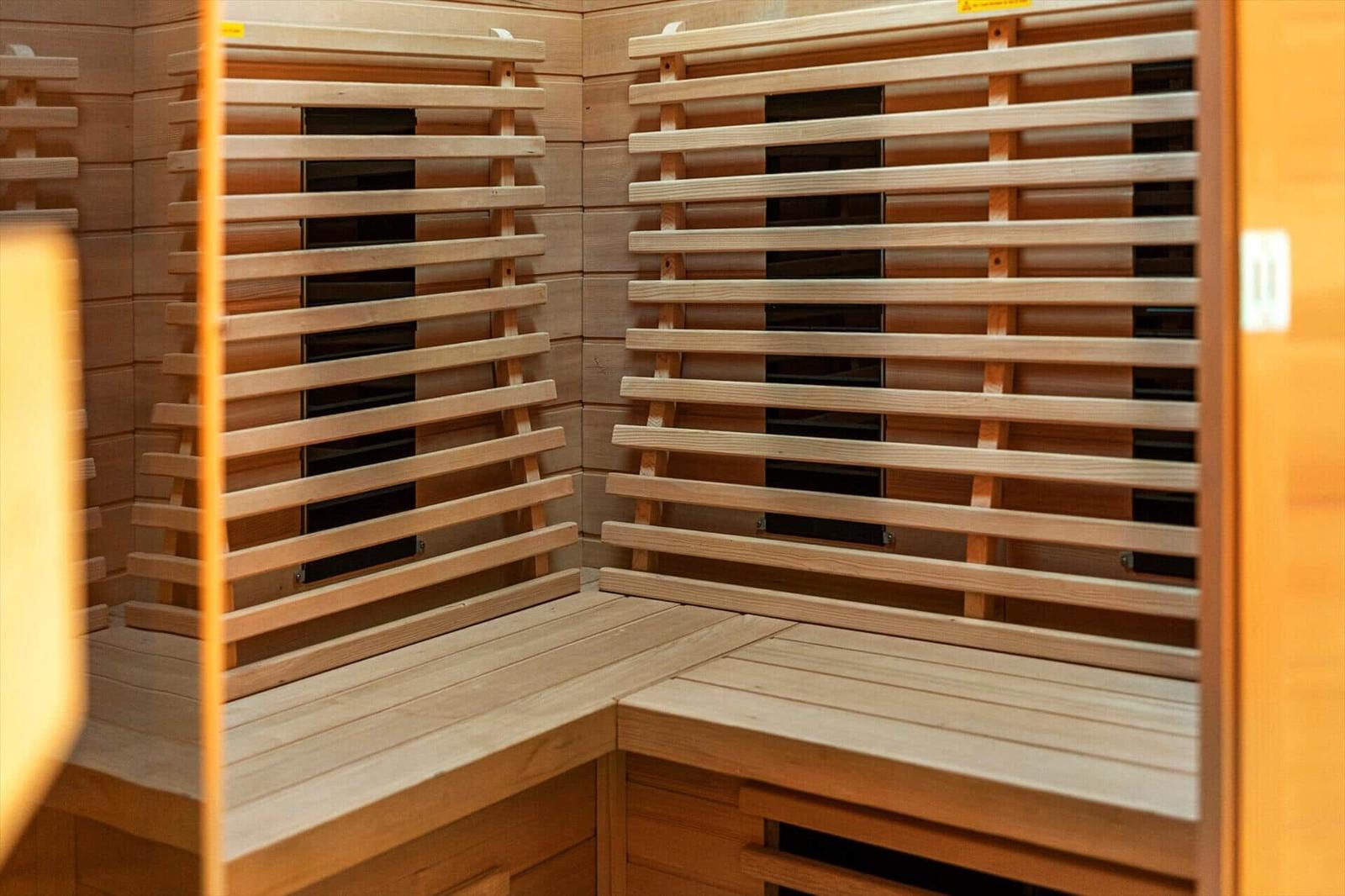 Sauna mit Holzbank und Wärmeelementen an den Wänden.