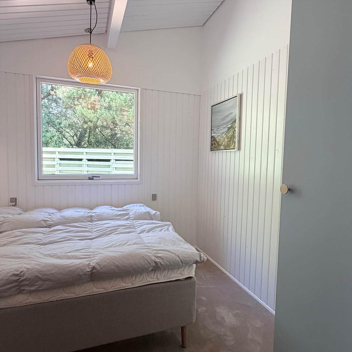 Schlafzimmer mit Bett, Fenster und Deckenleuchte