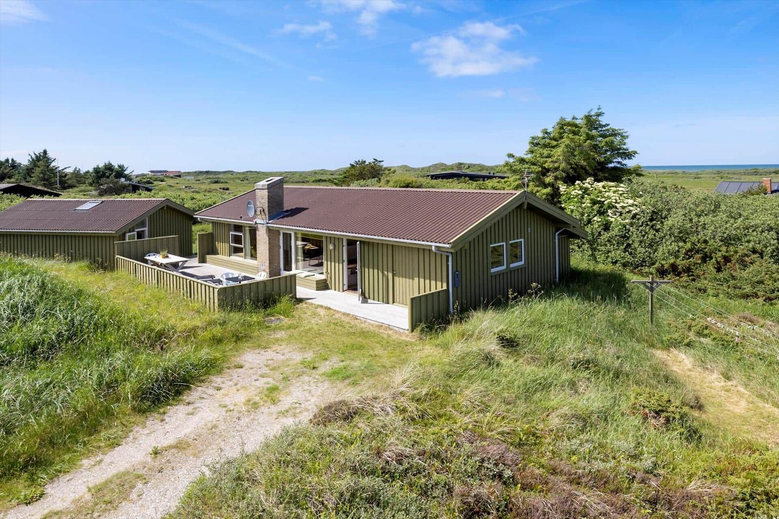 Holzhaus mit Terrasse und Blick auf die Küste