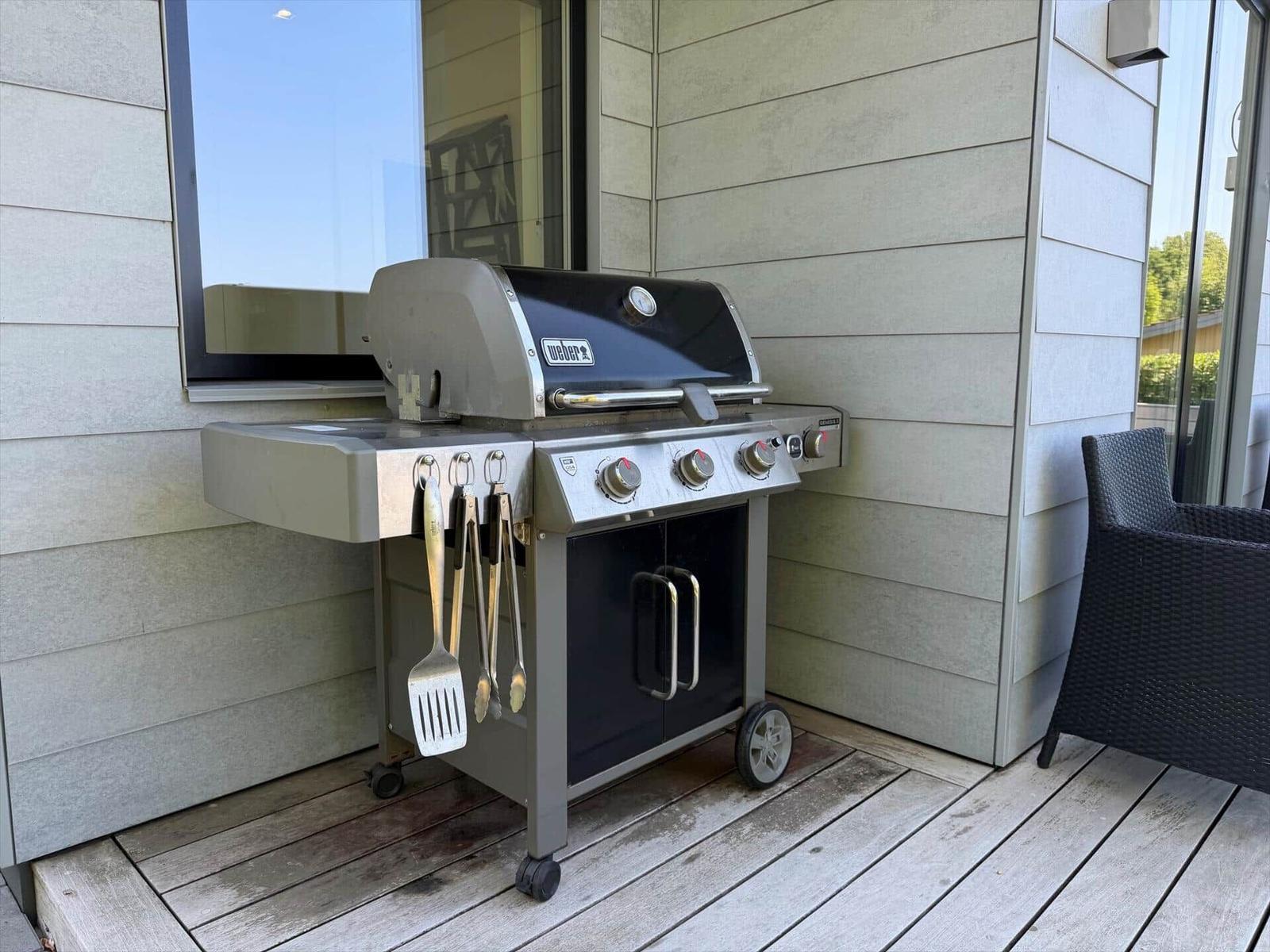 Außenbereich mit Grill und Sitzgelegenheit an moderner Fassade