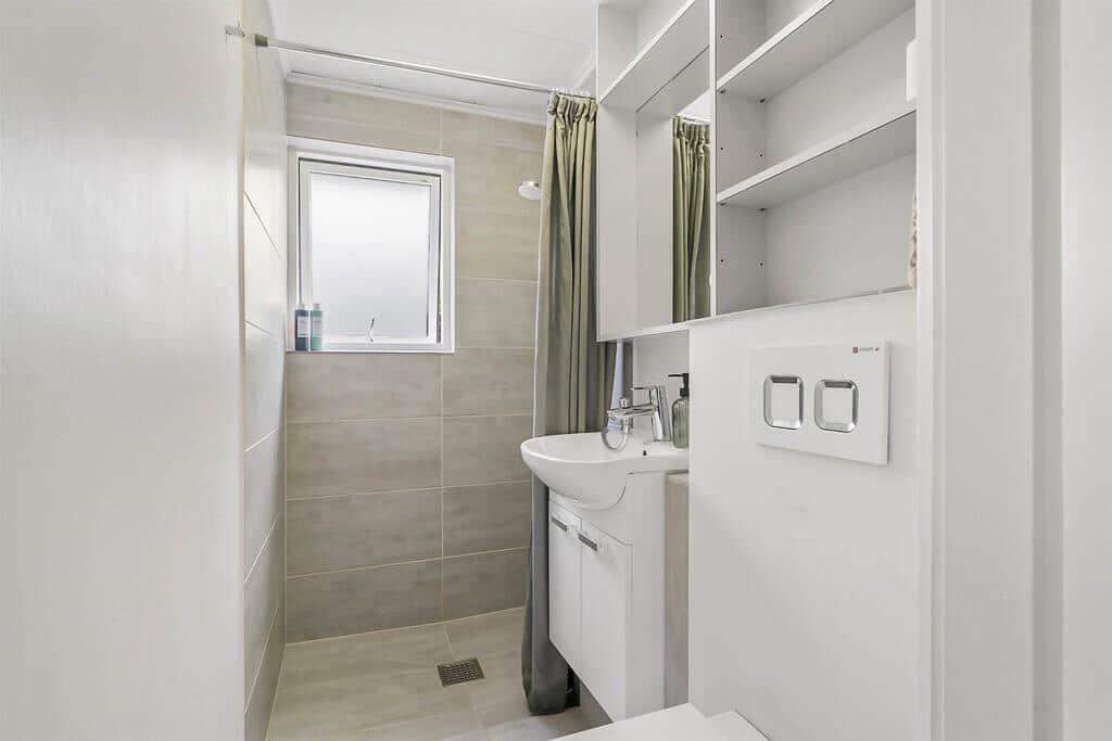 Bathroom with sink, shower, and window