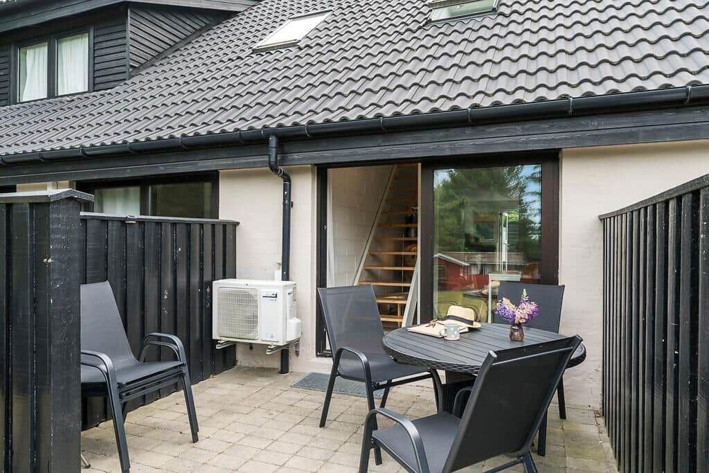 Terrace with table, chairs, and view into the house.