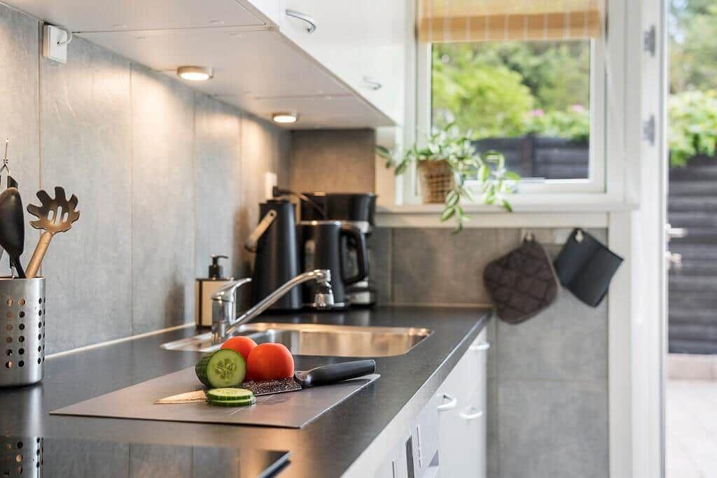 Kitchen with countertop, sink, and window with plant.