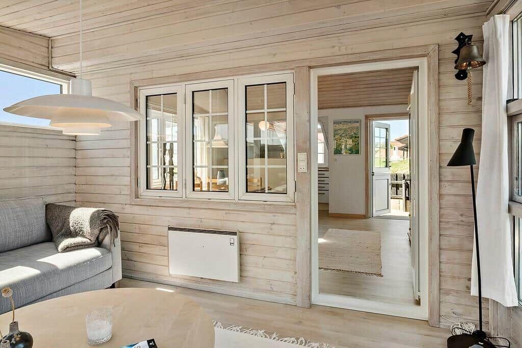 Living room with sofa, windows, and view into the kitchen