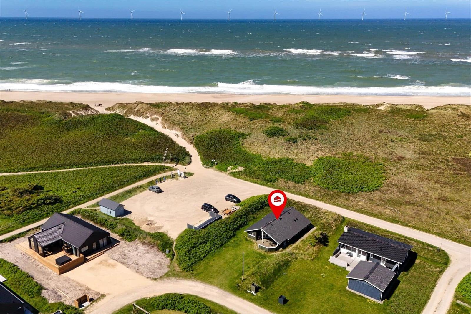 Haus mit Blick auf Strand und Windkraftanlagen