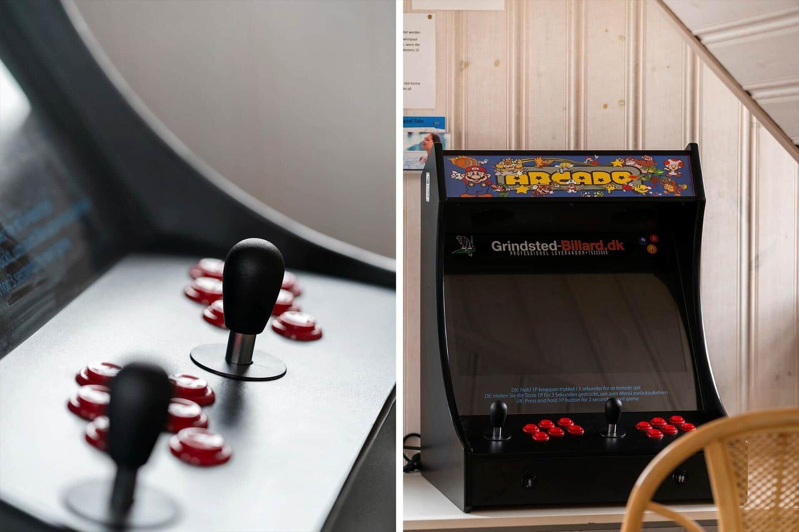 Arcade-Spielautomat mit Joystick und roten Tasten auf weißem Untergrund.