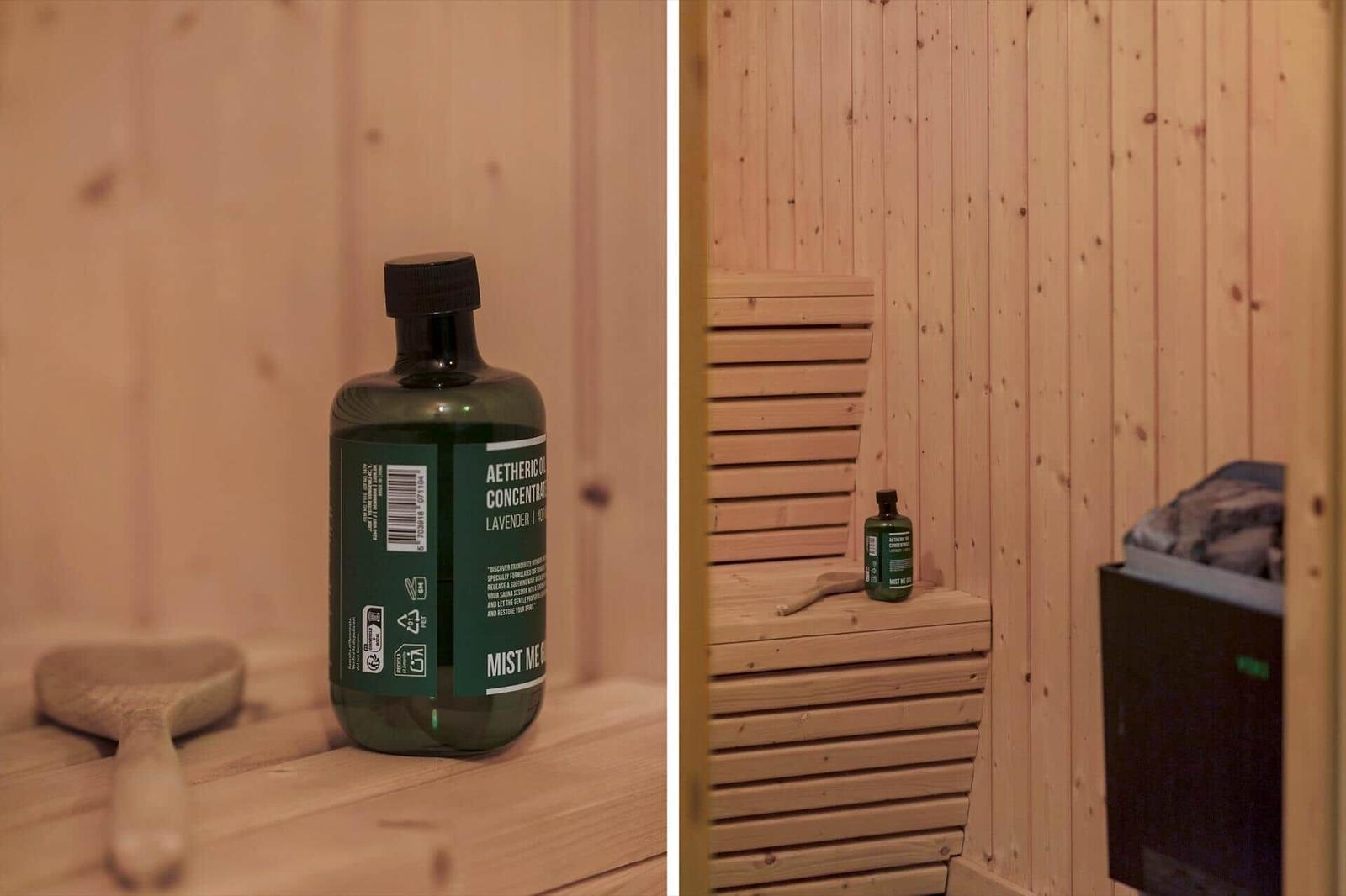 Sauna mit Holzwand, Aetheriköl und Bambusbürste auf Bank