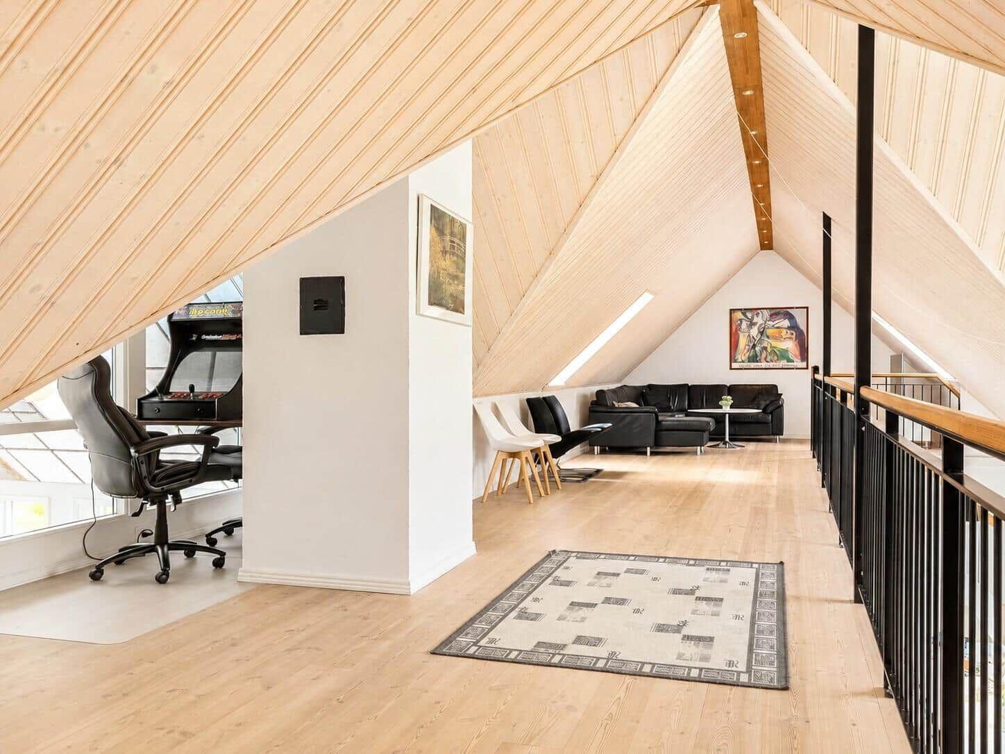 Dachgeschoss mit Spielzimmer und Wohnbereich unter Holzdecke.