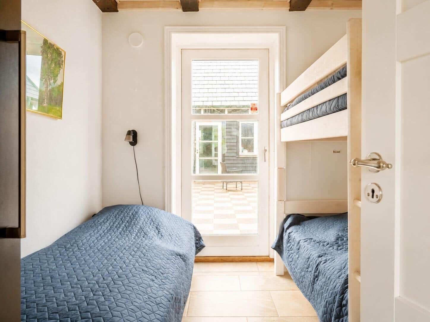 Zimmer mit Doppelstockbett und Tür zum Außenbereich