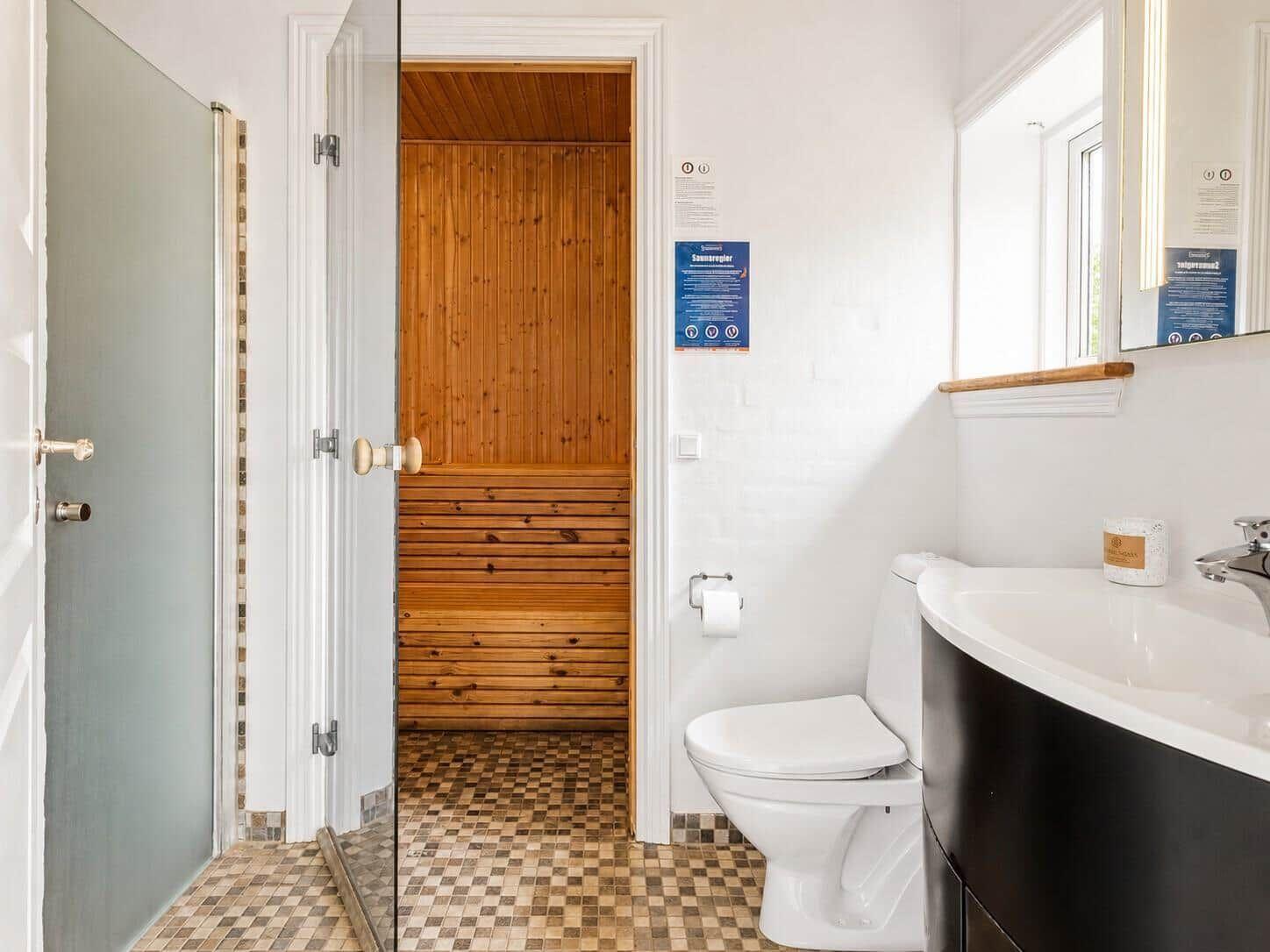 Badezimmer mit Toilette, Waschbecken und Sauna.
