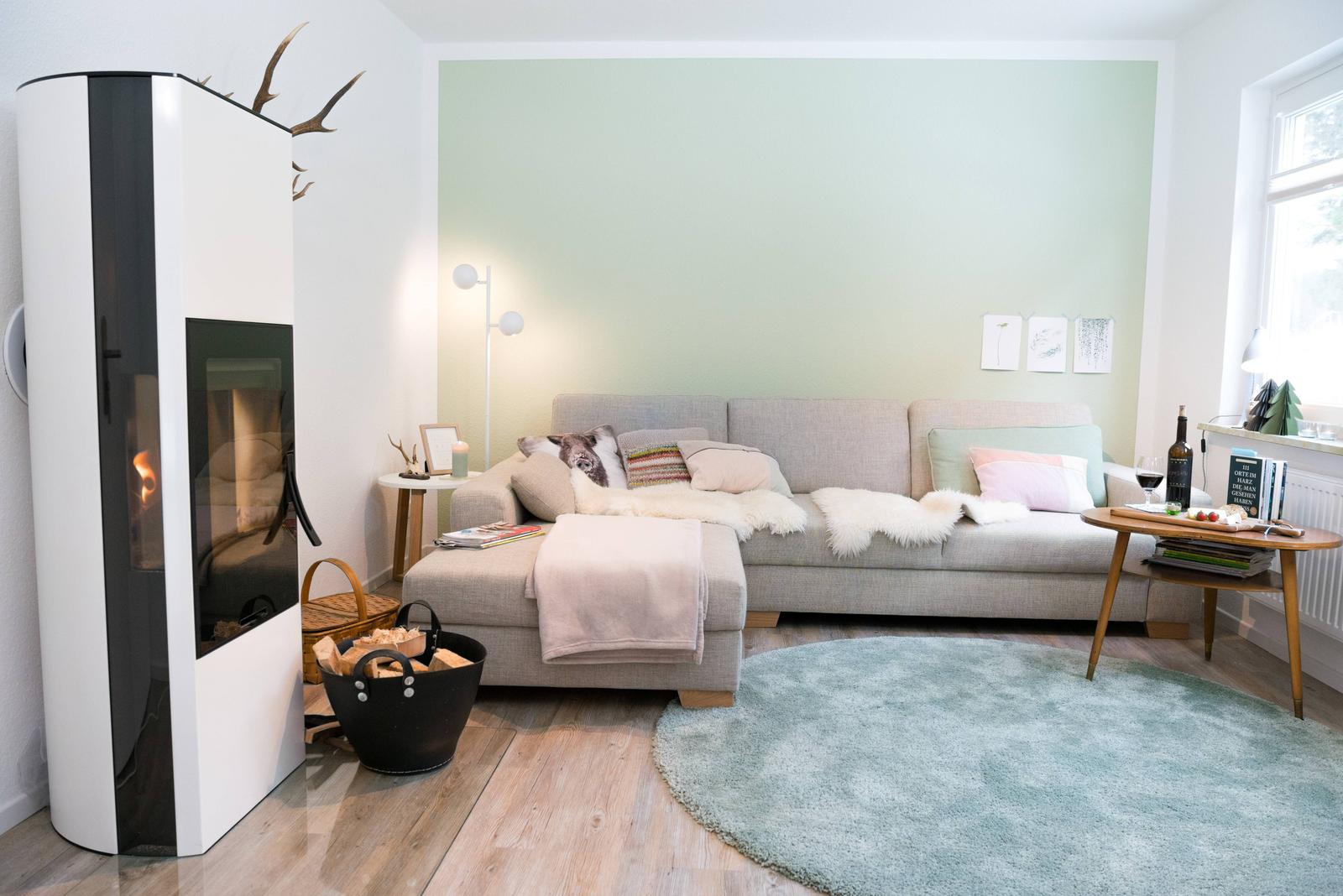 Wohnzimmer mit Sofa, Kamin und runden Teppich