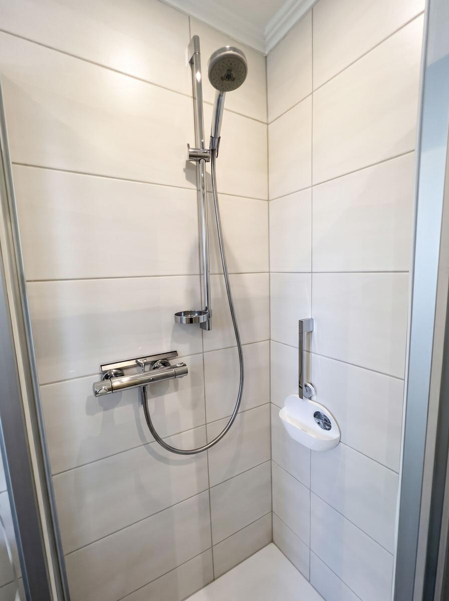 Dusche mit Duschbrause und Handbrause an Wand montiert