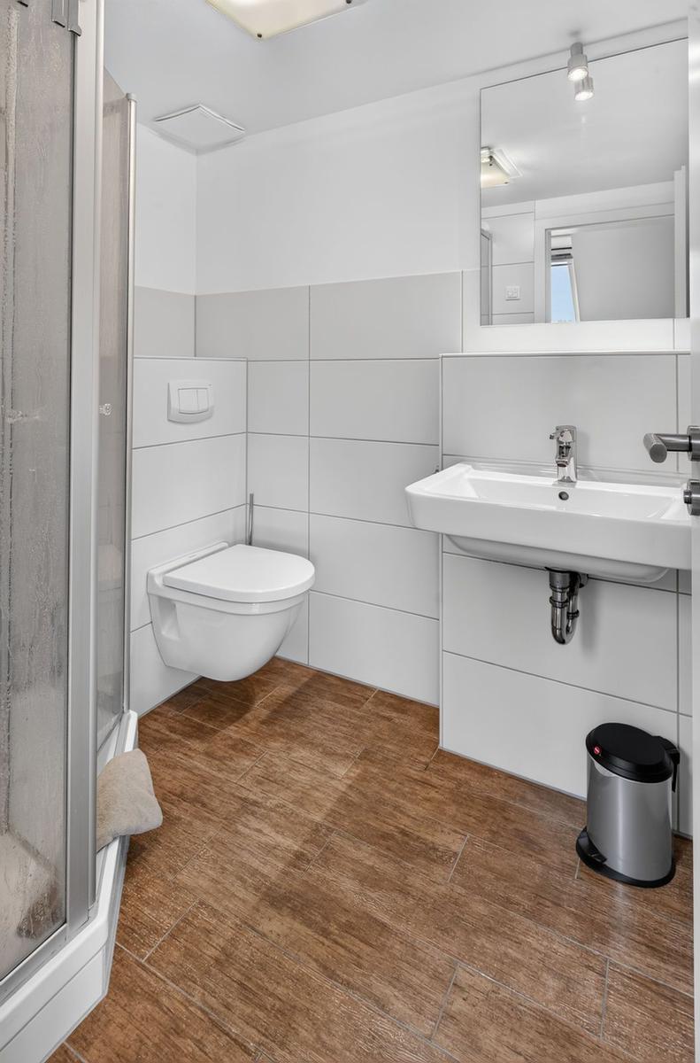 Badezimmer mit Dusche, Toilette und Waschbecken.