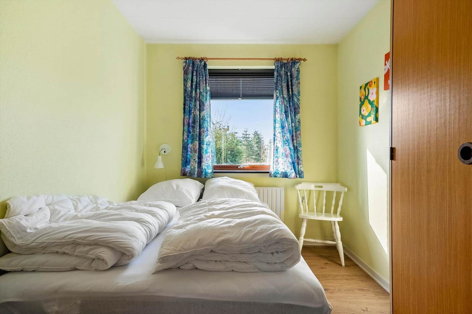 Zwei Einzelbetten, Fenster mit Blick auf Wald, Wandbild und Heizkörper.