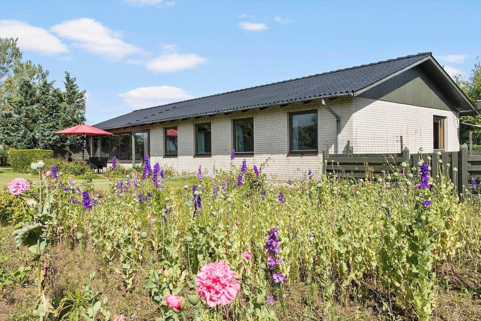 Ein Haus mit Garage, umgeben von Grünflächen und einem Blick auf Felder.