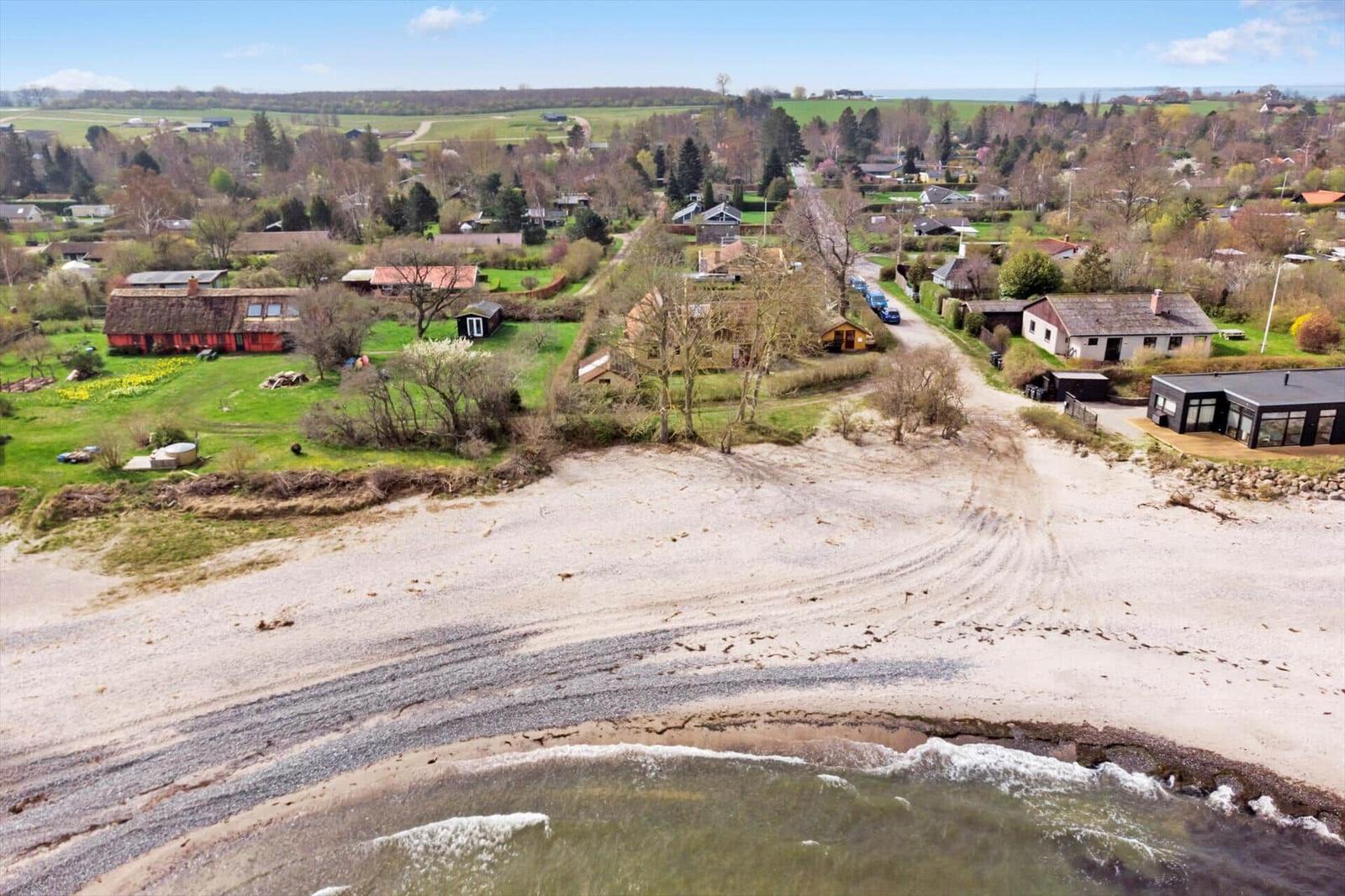 Haus mit rotem Dach neben Strand und See