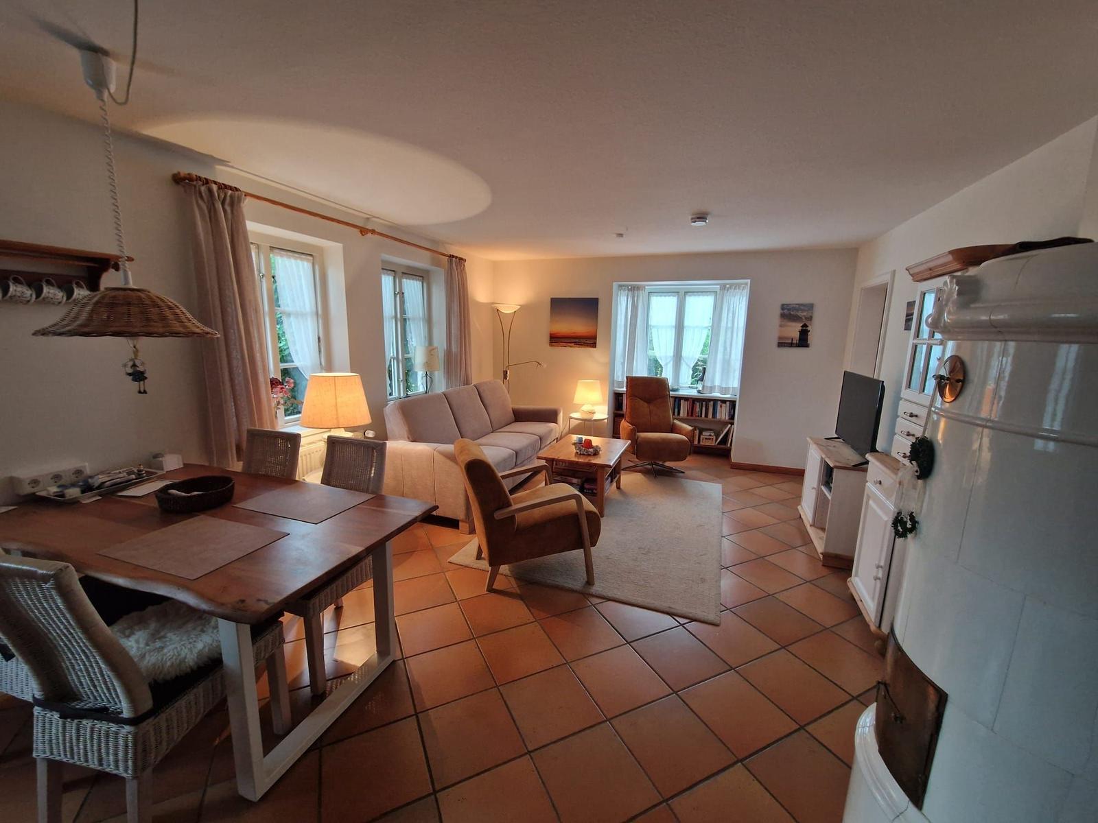 Wohn- und Essbereich mit Sofa, Stühlen und Terrassenfenstern.