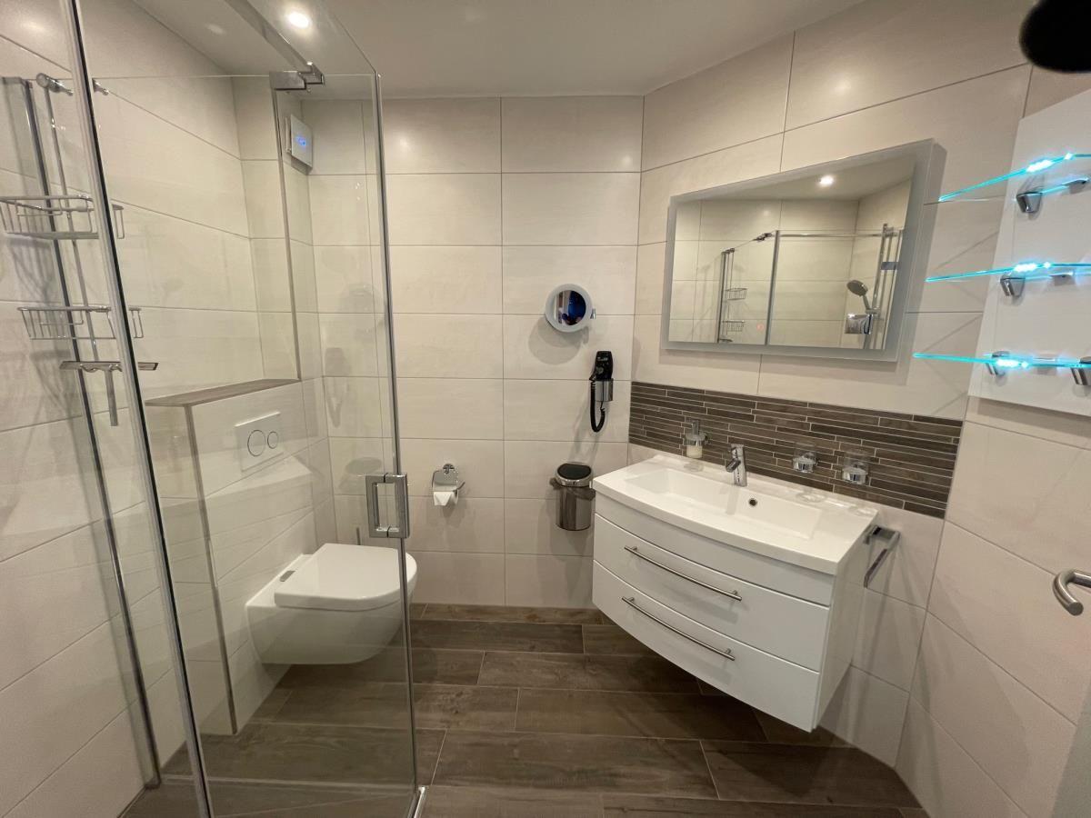 Moderne Badezimmer mit Dusche, Toilette und Waschbecken.