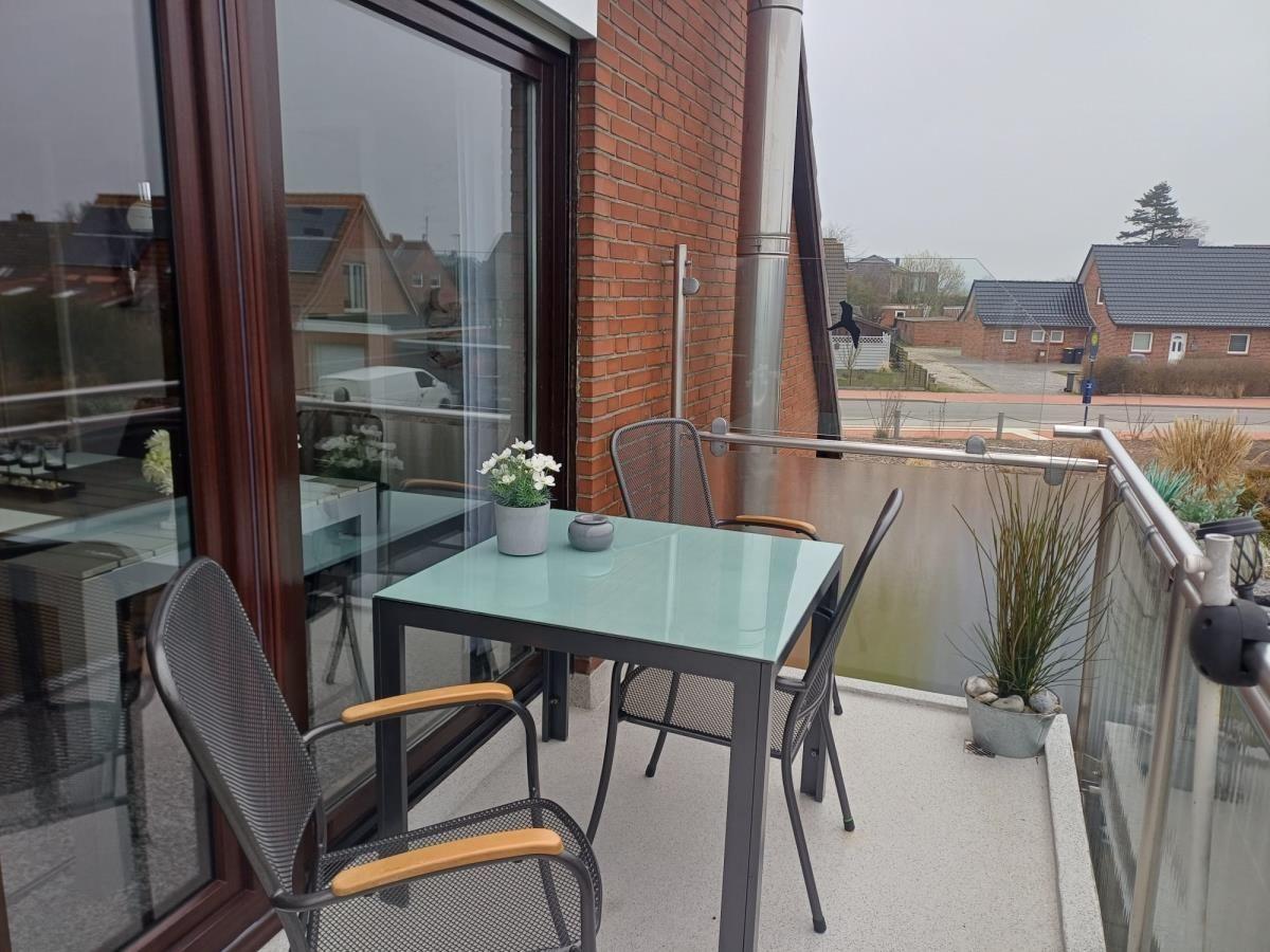 Terrasse mit Tisch und Stühlen, Pflanzen und Blick auf die Straße.