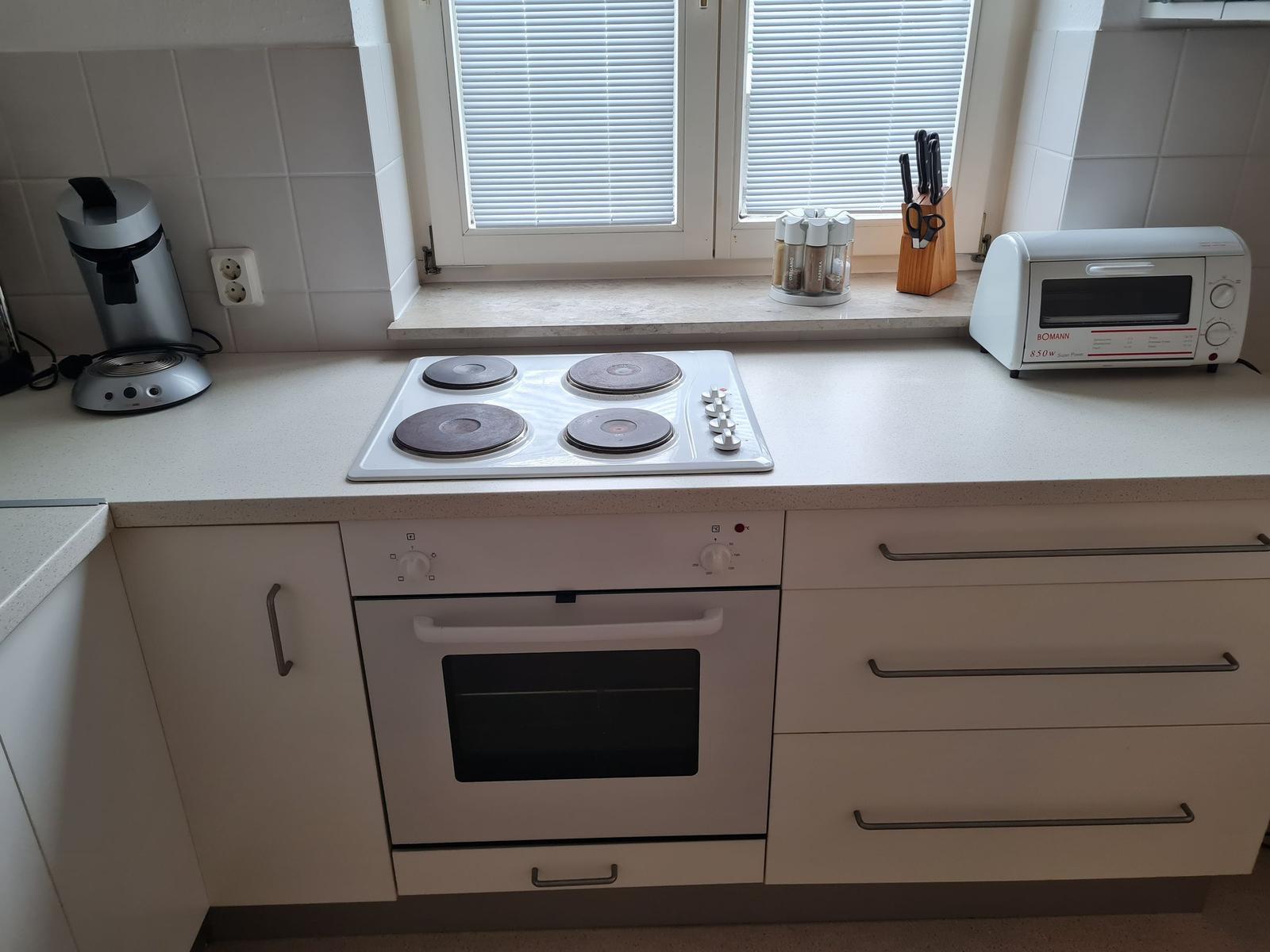 Küche mit Herd, Backofen, Toaster und Küchenzeile