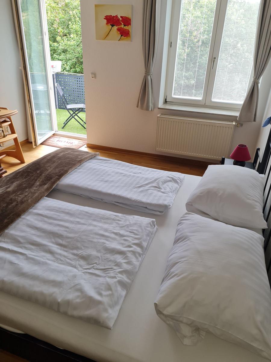 Schlafzimmer mit Doppelbett, Fenster und Terrassentür.